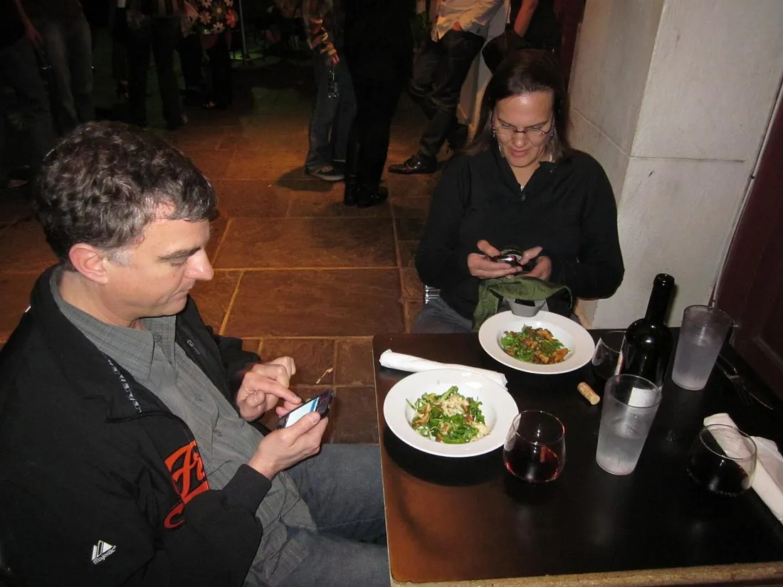 Friends at dinner checking their phones